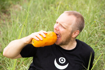 Caucasian hipster  sitting on grass with papaya, relax, happyness