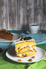 Pistachio cake, sponge cake with nuts decoration on a white plate.