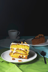 Pistachio cake, sponge cake with nuts decoration on a white plate.