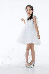 Naklejka premium Portrait isolated studio shot of little Asian cute ballerina kid in pink beautiful ballet dress with high heels standing smiling posing elegance gesture in front white background