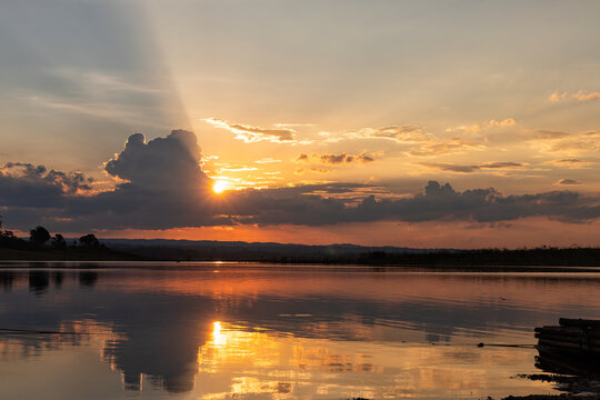 The sun sets on the Reservoir  NamHoum , depicting a traditional Asian sunset. This picture was taken  in May 2021. Beautiful sky and river on evining.