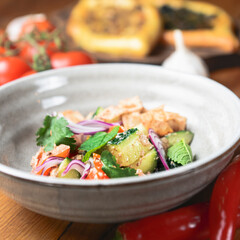 Salad with beef, onion and cilantro in sweet and sour sauce. Served in a bowl over rustic wooden background.