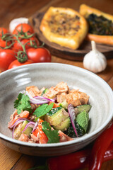 Salad with beef, onion and cilantro in sweet and sour sauce. Served in a bowl over rustic wooden background.