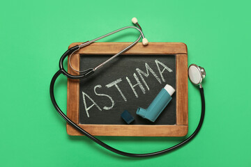Chalkboard with word ASTHMA, inhaler and stethoscope on color background