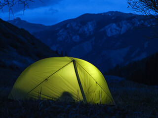 Night camping high in the mountains. Light in the tents. Multi-day trip