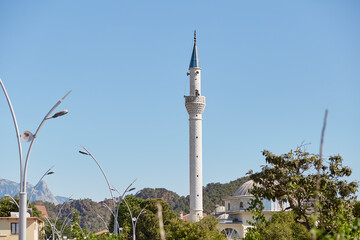 Obraz premium Old turkish minaret in Kemer on sunny day. Beautiful turkish landmark. Summer travel vacation concept