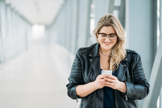 Gadget People. Mobile Communication. Social Media. Body Positive. Happy Smiling Overweight Chubby Obese Woman Using Phone For Online Chat On Light Blur Empty Space Background.