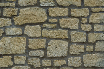 Yellow wall are made of uneven stones of random shapes and sizes