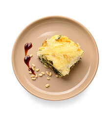 Plate with piece of tasty green lasagna and sauce on white background