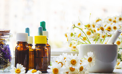 Medicinal herbs in bottles. chamomile oil extract. Selective focus.
