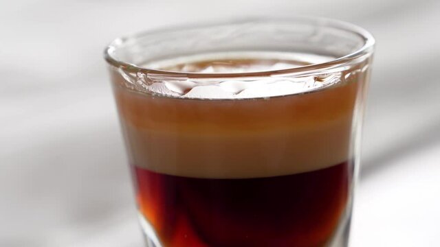 Closeup Of A Shot Glass Filled With B-52 Cocktail. Layered Shot With Coffee Liqueur, Irish Cream, And Orange-Flavoured Triple Sec.