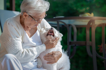 Happy Senior woman of 80 years old playing to her pet while relaxing home