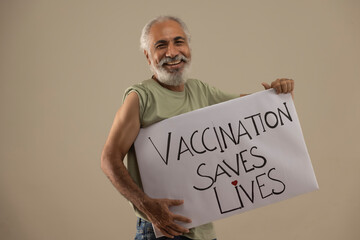 A HAPPY OLD MAN STANDING WITH VACCINATION AWARENESS POSTER