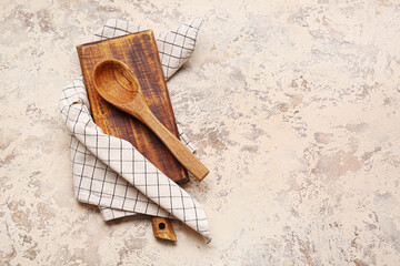 Fabric napkin, wooden board and spoon on grunge background