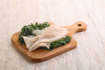 Raw squid over wooden board