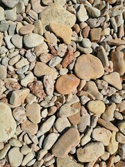 small pebbles on the shore of the lake stony background
