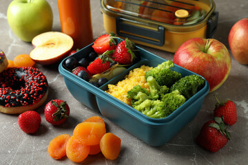 Lunch boxes with tasty food on gray textured table