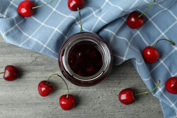 Fototapeta na wymiar Cherry jam and ingredients on gray textured table