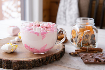 Hot drink with marshmallows on a wooden table.