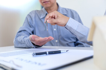 Sales manager giving advice application form document, considering mortgage loan offer for car and house insurance.