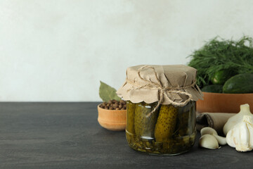 Fresh pickles and ingredients on dark wooden table