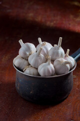 Garlic in pot on brown wooden table