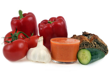 Verre de gaspacho entouré de ses ingrédients sur fond blanc