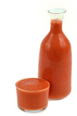 Verre et bouteille de gaspacho en gros plan sur fond blanc