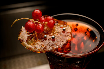 glass with drink with beautiful decoration of caramel crust and red currant berries
