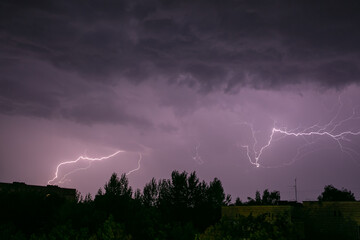 Naklejka na ściany i meble Lightning during a storm over the city in the nightLightning during a storm over the city in the night