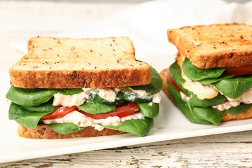 Plate with tasty sandwiches on light background, closeup