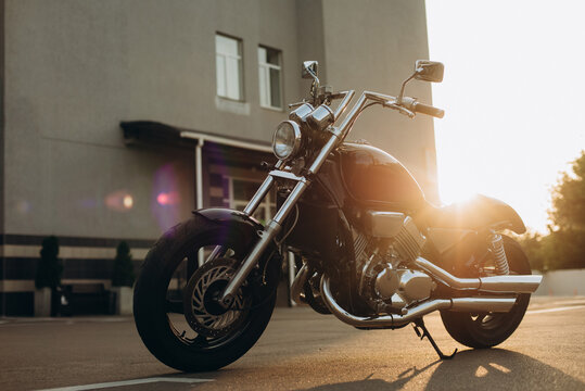 Freedom. Motorcycle in the parking lot in the rays of the sunset light. Stylish custom chopper motobike with chrome details. Soft selective focus.