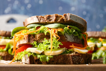 Board with tasty sandwich on color background, closeup