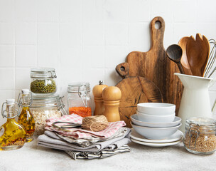 Kitchen utensils, tools and dishware on on the background white tile wall.