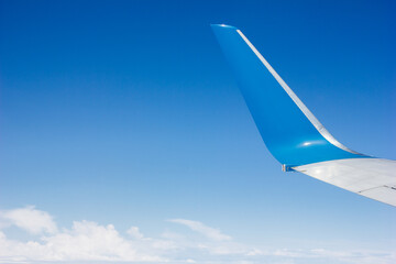 Boeing plane tail blue sky and white clouds aerial view from plane window, theme of air travel and travel, copy space for text - obrazy, fototapety, plakaty