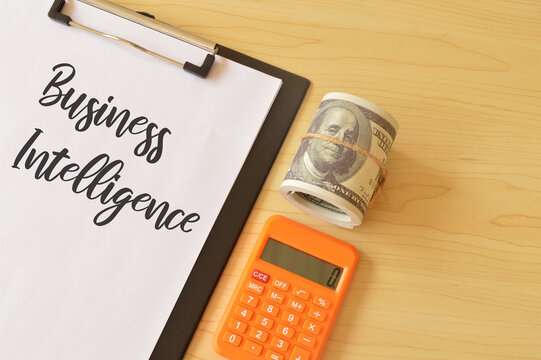 Money banknote, calculator and file with text BUSINESS INTELLIGENCE.