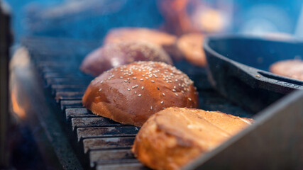 Frying burger buns in a frying pan on grill. BBQ. Street Food
