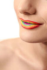 Beautiful young woman with rainbow lips on white background, closeup