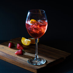 Aperol Spritz red aperitif cocktail in glass with ice on black background