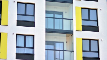 Obraz premium Modern apartment buildings on a sunny day with a blue sky. Facade of a modern apartment building. Glass surface with sunlight.