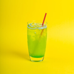 green fresh cocktail smoothie jusice in glass with ice on yellow background. vitamin drink detox