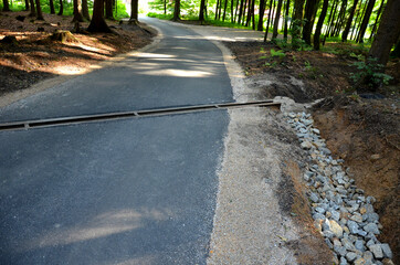 renovation of asphalt road in the mountains. The ditches are filled with stones to slow down the...