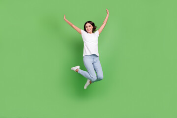 Full size photo of cool brunette millennial lady jump wear t-shirt jeans isolated on green color background