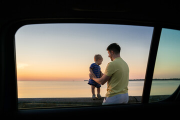 Father with his daughter, road trip near sea, sunrise evening sky, parent with child, little baby do her first step