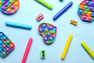 Naklejka premium Pop it fidget toys and stationery on color background