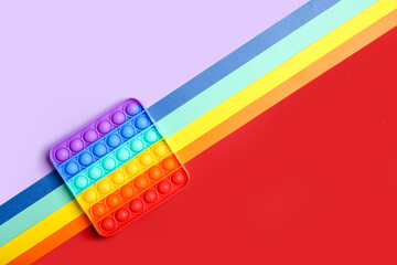 Rainbow pop it fidget toy on color background - obrazy, fototapety, plakaty