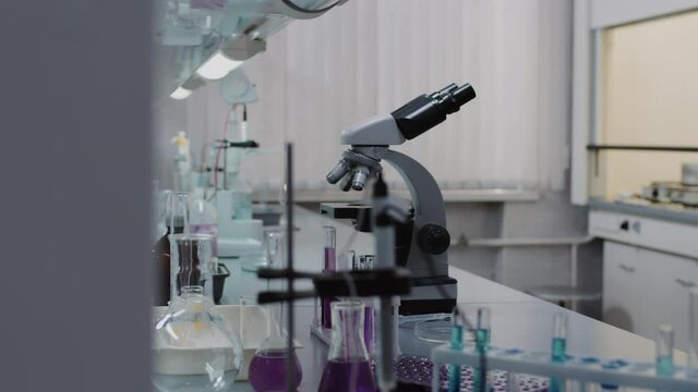 Slowmo tracking shot of interior of chemistry lab Microscope, test tubes in rack, beakers and flasks are on table