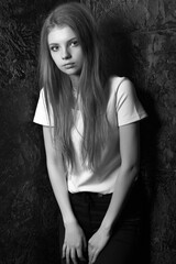 Stylish dressed stunning woman posing in a dark room