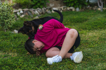 Niño jugando con un perro de raza pastor alemán en el jardín