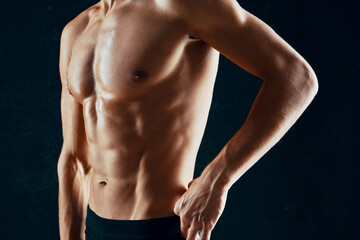Fototapeta na wymiar sporty man with a pumped-up muscular body in a towel dark background